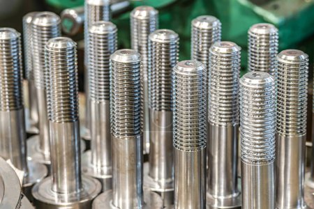Photo for Threaded bolts made on a lathe stand on a rack in a warehouse. - Royalty Free Image
