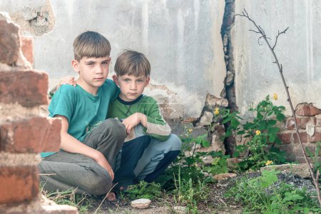Enfants dans une maison abandonnée, deux pauvres garçons abandonnés, orphelins à la suite de catastrophes naturelles et d'actions militaires. Photo de soumission
.