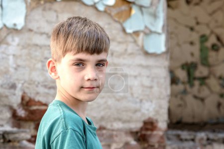 Children in an abandoned and destroyed building in the zone of military and military conflicts. The concept of social problems of homeless children. Staged photo.
