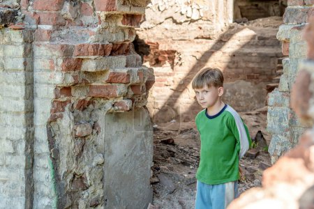 Enfants dans un bâtiment abandonné et détruit dans la zone de conflits militaires et militaires. Le concept des problèmes sociaux des enfants sans abri. Photo mise en scène
.