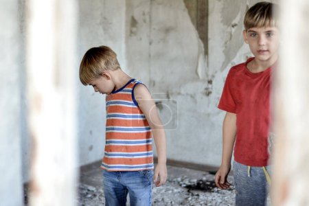 Kinder in einem abgebrannten Haus verloren infolge von Feindseligkeiten und Naturkatastrophen ihr Zuhause.
