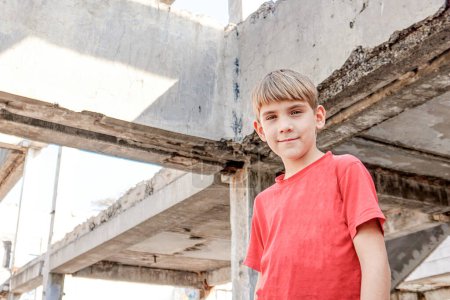 Un garçon sale et affamé dans un bâtiment abandonné à la recherche d'asile.