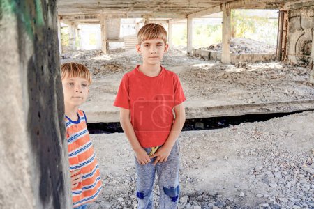 Arme und schmutzige Straßenkinder, die auf einer verlassenen Baustelle leben.
