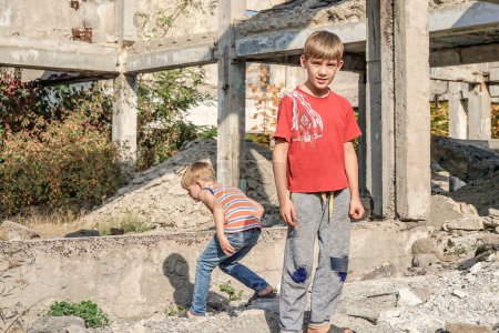 Foto de Dos niños pobres y sucios buscan comida y refugio en la basura
. - Imagen libre de derechos