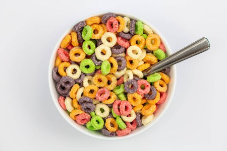 Foto per Cereali colorati per la colazione in una ciotola su sfondo bianco, posa piatta, colazione sana per bambini, primo piano. - Immagine Royalty Free