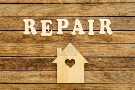 Photo for Word Repair made of wooden letters and house model on a wooden background, flat lay. - Royalty Free Image
