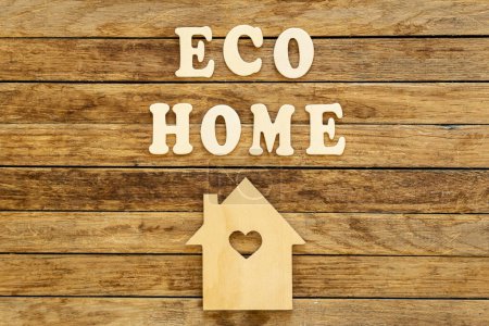 Foto de Inscripción Eco casa hecha de letras de madera y modelo de casa sobre un fondo de madera, plano. - Imagen libre de derechos