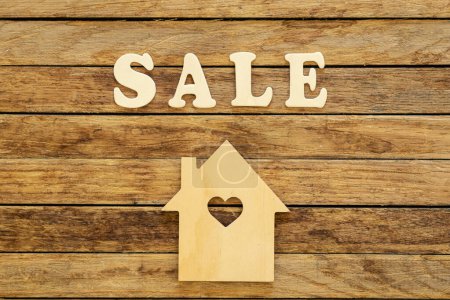 Photo for Word Sale made of wooden letters and house model on a wooden background, flat lay. - Royalty Free Image
