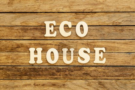 Foto de La inscripción Eco casa hecha de letras de madera sobre un fondo de madera, vista superior. - Imagen libre de derechos