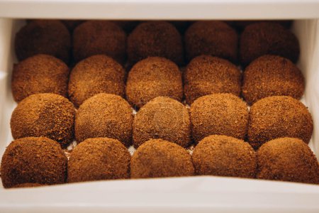 Photo for Chocolate balls with cocoa powder on a confectionery shop window, close-up. Sweet chocolate truffle, rum balls cakes. - Royalty Free Image