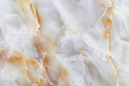 Cette photo capture la beauté céleste du marbre blanc, accentué par des flots d'ambre et de tendres veines d'ivoire qui se tissent à travers la pierre comme de l'or liquide.