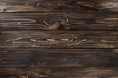 Esta cautivadora imagen presenta tablones de madera carbonizados, cada uno con su propio patrón de grano único resaltado por el proceso de charring.