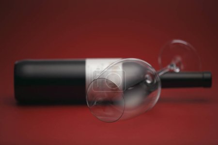 Téléchargez les photos : Bouteille de vin et verre de vin sur fond rouge - en image libre de droit