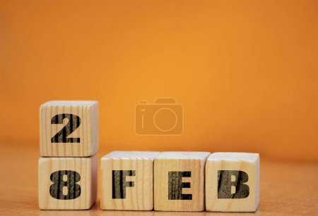 Foto de Cube shape calendar for february 28 on wooden surface with empty space for text, new year Wooden calendar with date, February cube calendar on wooden surface with copy space. - Imagen libre de derechos