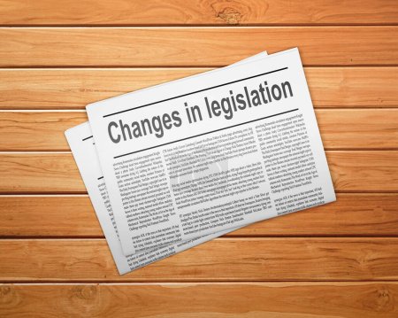 Photo for A newspaper on a wooden desk, newspaper with the headline Changes in legislation - Royalty Free Image