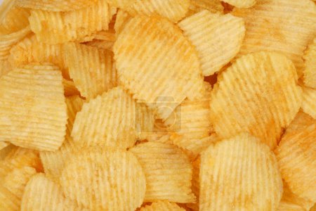 Des chips croustillantes en macro. Pommes de terre dorées frites de près. Collation de pommes de terre pour la restauration rapide malsaine. 
