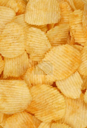 Des chips croustillantes en macro. Pommes de terre dorées frites de près. Collation de pommes de terre pour la restauration rapide malsaine. 