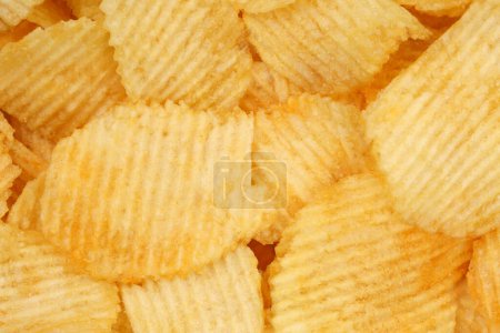 Crispy potato chips rotating in macro. Golden fried potatoes close up. Potato snack for unhealthy fast food.