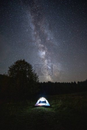 Foto de Tienda de campaña en la noche contra el increíble cielo lleno de estrellas y la vía láctea - Imagen libre de derechos