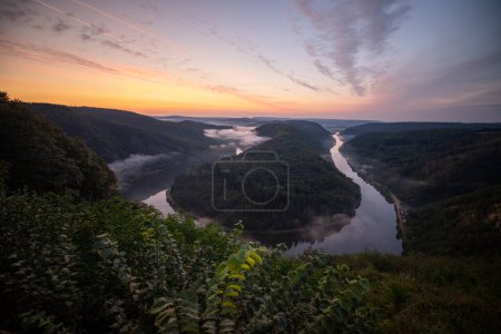 Photo for Foggy morning at Saarschleife river loop in Saarland, Germany. Aerial drone view - Royalty Free Image