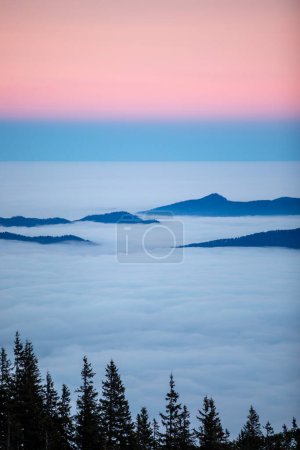 Téléchargez les photos : Beau lever de soleil rose dans les montagnes couvertes de neige et de nuages - en image libre de droit