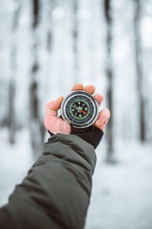 Foto de Man holding compass in hand at winter time - Imagen libre de derechos