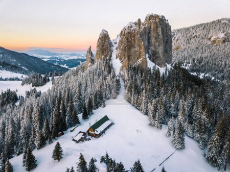 Foto de Hermosa puesta de sol majestuosa en las montañas de invierno, pinos cubiertos de nieve, dron aéreo tiro dramático. En las montañas Hasmas, Rumania. - Imagen libre de derechos