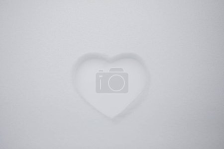 Photo for Heart shape on natural pure white soft snow surface in a cold weather day. Symbol of love in winter holiday season. Romantic outdoor concept for Valentine's day with copy space. - Royalty Free Image