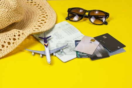 Téléchargez les photos : Chapeau de paille, cartes de crédit, avion, lunettes de soleil, livre de compte, budgétisation et dépenses dans le plan de voyage ou voyage vacances concept financier - en image libre de droit