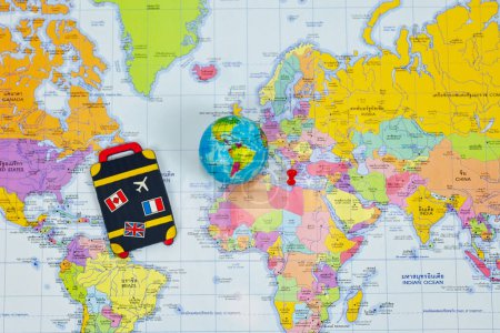 Téléchargez les photos : Sac à bagages tag, globe, rouge push pin comme destinations de rêve sur la carte de l'atlas du monde avec traduction thaïlandaise, voyage, concept d'explorateur du monde - en image libre de droit