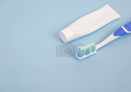 Toothpaste, toothbrush with toothpaste on blue background, health care lifestyle, oral dental care product, copy space