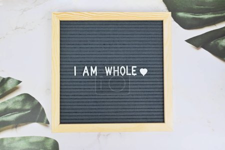 Photo for Grey letter board with phrase I am whole, self love, self care on natural background. Mindfulness lifestyle, mental health. Aspiration and supportive sentence - Royalty Free Image