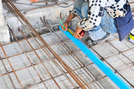 Photo for Worker measuring pipe with measure tape pipe at construction site - Royalty Free Image