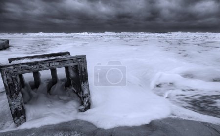 Photo for A wooden trash crate floats in the surf during high tide at Jacksonville Beach, Florida. - Royalty Free Image