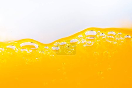 Close up bright orange juice splash texture for health and nature waves, Beautiful waves curve and little bubbles smooth for garphic design and background