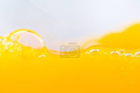 Close up bright orange juice splash texture for health and nature waves, Beautiful waves curve and little bubbles smooth for garphic design and background