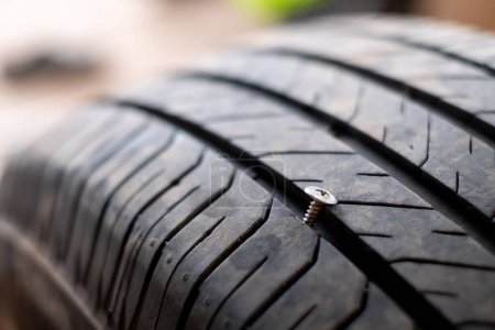 Photo for Car tire puncture due to running over a bolt - Royalty Free Image