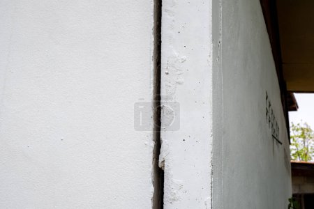 Muro de hormigón agrietado pared rota en la esquina exterior de cemento que se llevó a cabo con terremoto y suelo colapsado