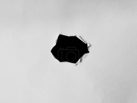 Foto de Marco de papel con los agujeros rasgados. un agujero negro en el papel blanco. para el espacio de copia superposición de fondo - Imagen libre de derechos