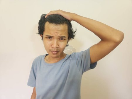 Foto de Shocked cara de asiático hombre consiguiendo calvo y perdido cabello en aislado blanco fondo - Imagen libre de derechos