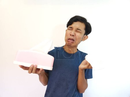 Foto de Llorando cara de hombre asiático con la mano sosteniendo tejido aislado sobre fondo blanco - Imagen libre de derechos
