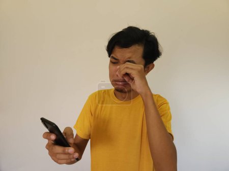 Téléchargez les photos : Homme pleurant et déçu de son téléphone. Annonce promotionnelle manquée - en image libre de droit