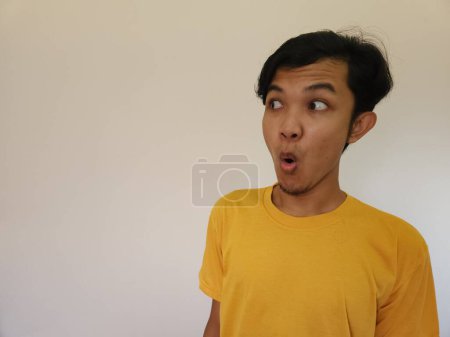 Foto de Funny amazing shocked surprised asian man face advertise isolated on white - Imagen libre de derechos