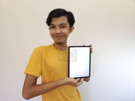 Téléchargez les photos : Asiatique Homme montrer avec l'écran vide de la tablette - en image libre de droit