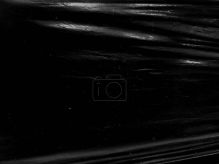 Foto de Una textura de plástico transparente negro con agujero para el cartel y el arte de la portada. envoltura de plástico realista para superposición, espacio de copia y efecto de foto. superficie plástica arrugada sobre fondo negro - Imagen libre de derechos