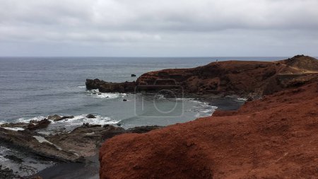 Photo for Charco de los Clicos viewpoint, Las Palmas, Spain. A great vantage point overlooking a black beach and cliffs of varying shades. A nicely landscaped bay - Royalty Free Image