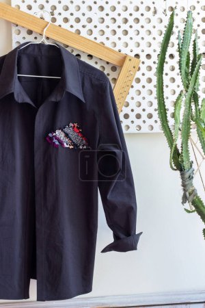 Foto de Adorno de tela hecha en casa reciclada en una camisa de algodón negro. En bicicleta. moda sostenible. telar de madera - Imagen libre de derechos