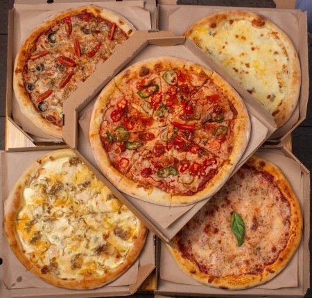Set aus verschiedenen gebackenen Pizzen auf einem Holztisch. Speisekarte für Restaurant, Pizzeria. Sortiment an Pizzen.