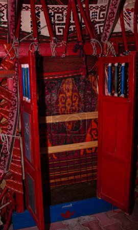 Téléchargez les photos : Porte en bois décorée de motifs et de tissus dans une yourte traditionnelle kazakhe. Maison des nomades. - en image libre de droit