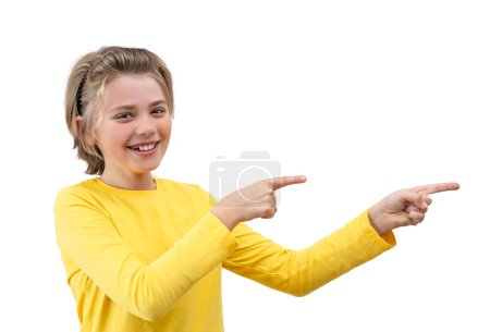 Astonished Emotional School boy happily Joy Showing To Right Isolated PNG Over White Background. Copy Space For Advertisement. Excited Blond Kid With Long Hair And Yellow T-Shirt